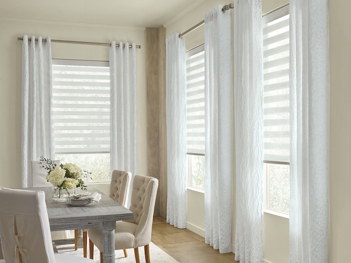 A dining room with white floor-to-ceiling drapery.